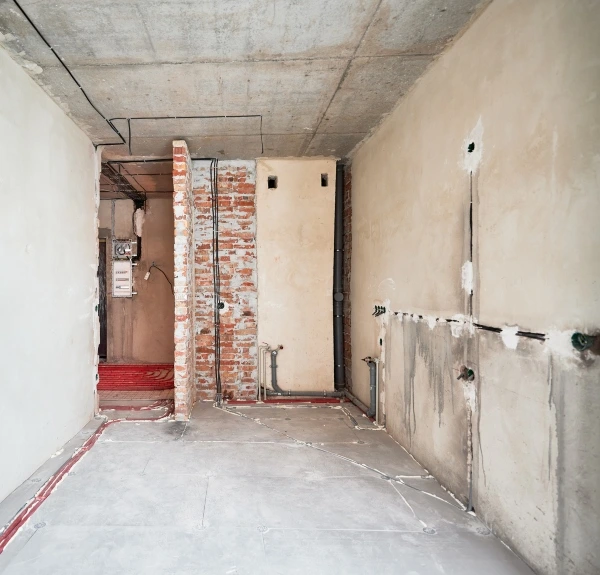 Kitchen renovation in progress with exposed brick and wiring